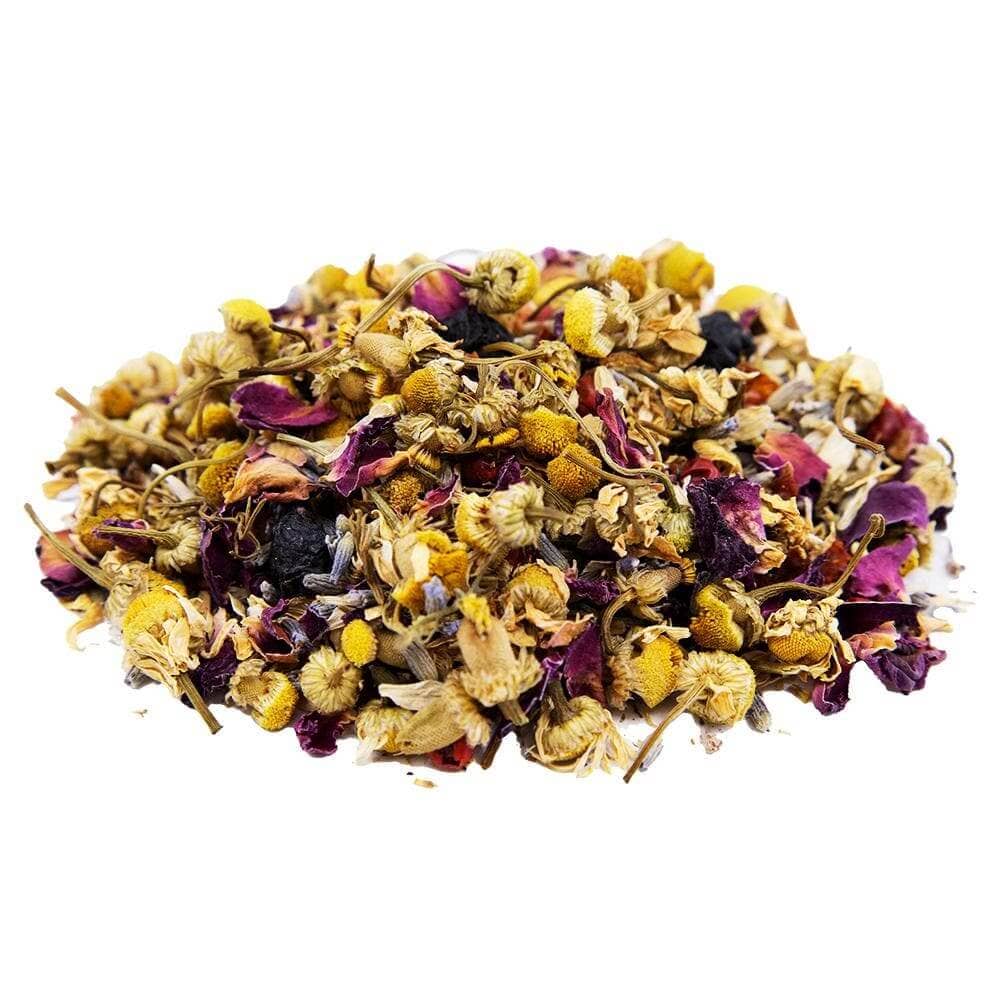 A pile of loose-leaf herbal tea blend featuring dried chamomile flowers, rose petals, and small yellow blossoms on a solid white background.
