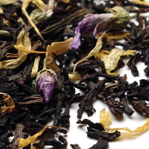 Assorted dried black tea leaves with flowers on a white background